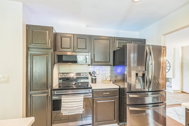 12720 Parkwood Dr, Burnsville, MN 55337 - kitchen featuring appliances with stainless steel finishes, decorative backsplash, light countertops, and tile patterned flooring