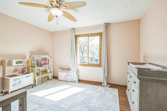 12720 Parkwood Dr, Burnsville, MN 55337 - rec room with wood finished floors, ceiling fan, and baseboards