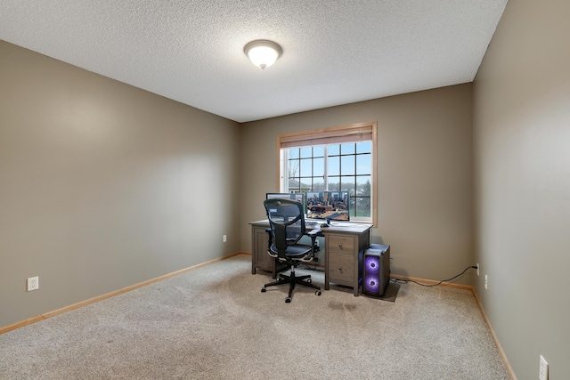 carpeted office featuring a textured ceiling and baseboards