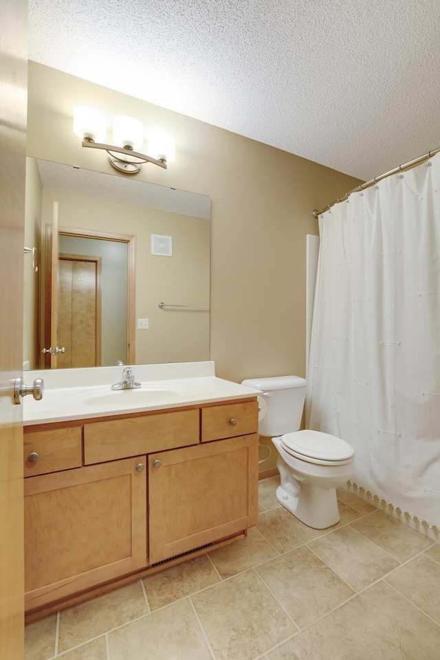bathroom with vanity, toilet, and a textured ceiling