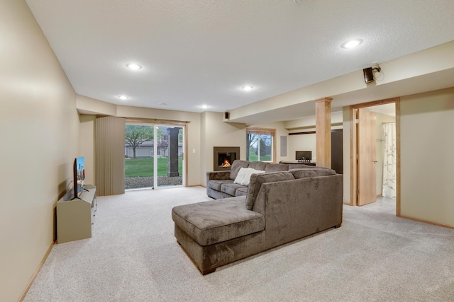 carpeted living room with recessed lighting, baseboards, and a warm lit fireplace