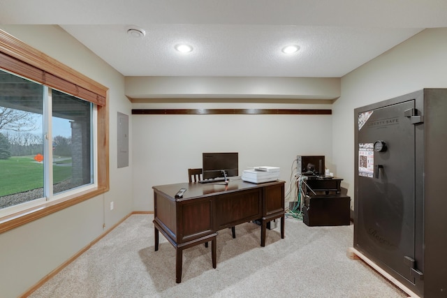 home office featuring baseboards, a textured ceiling, electric panel, and light carpet