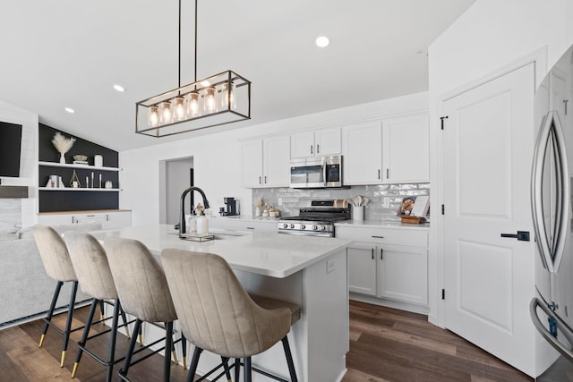 10257 Greenway Cir S, Cottage Grove, MN 55016 - kitchen with stainless steel appliances, a sink, white cabinetry, dark wood-style flooring, and a kitchen breakfast bar