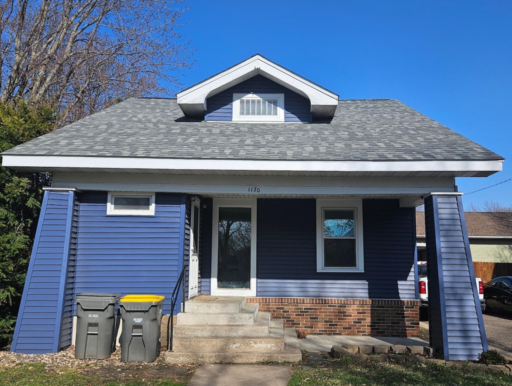 view of front of house featuring roof with shingles and covered porch