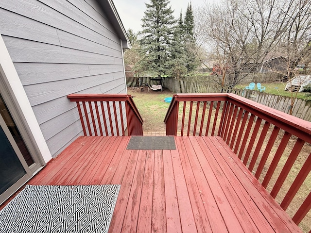 deck with a fenced backyard and a lawn