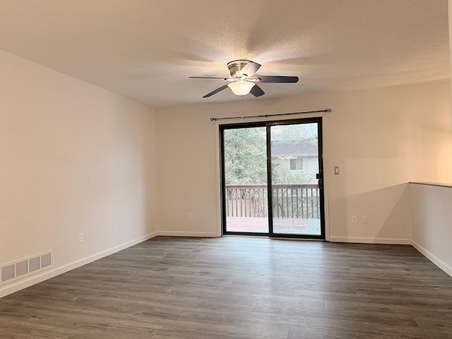 unfurnished room with baseboards, visible vents, ceiling fan, and dark wood finished floors