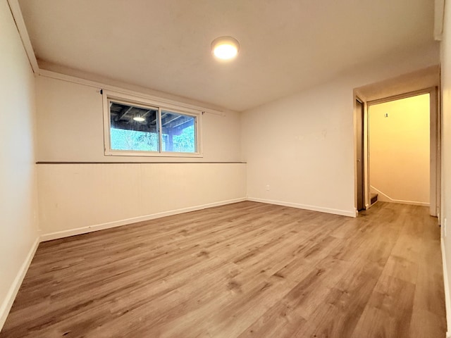 unfurnished room with wood finished floors and baseboards
