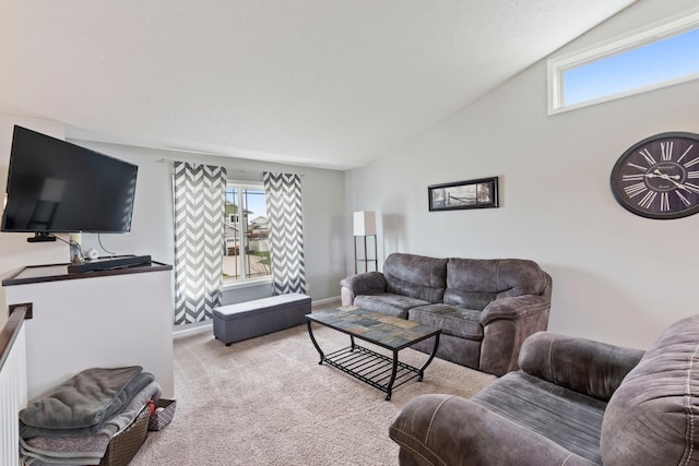 living area with carpet floors, baseboards, plenty of natural light, and vaulted ceiling