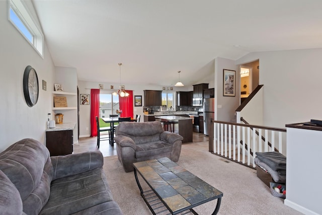 living room with baseboards, vaulted ceiling, and light carpet
