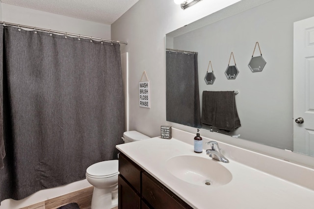 full bathroom featuring vanity, a shower with curtain, toilet, and a textured ceiling
