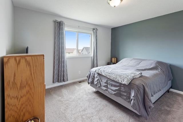 carpeted bedroom featuring baseboards and visible vents
