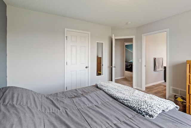 bedroom featuring baseboards and visible vents