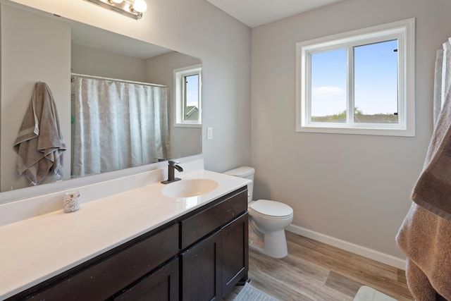 bathroom featuring vanity, wood finished floors, toilet, baseboards, and a shower with curtain