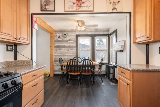 515 6th Ave, Grand Rapids, MN 55744 - dining space featuring radiator heating unit, a ceiling fan, wood walls, and dark wood-type flooring