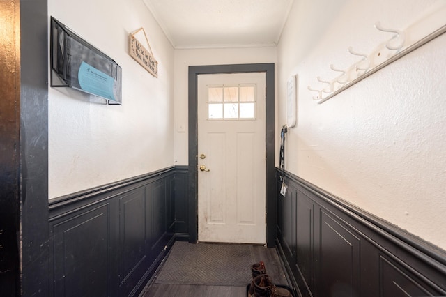 515 6th Ave, Grand Rapids, MN 55744 - doorway with a wainscoted wall, dark wood-style flooring, crown molding, and a decorative wall