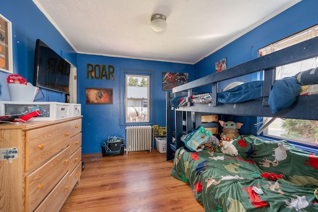 515 6th Ave, Grand Rapids, MN 55744 - bedroom featuring a textured ceiling, wood finished floors, ornamental molding, and radiator
