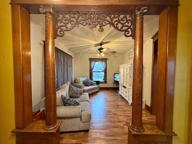 living room featuring baseboards, decorative columns, ceiling fan, and wood finished floors