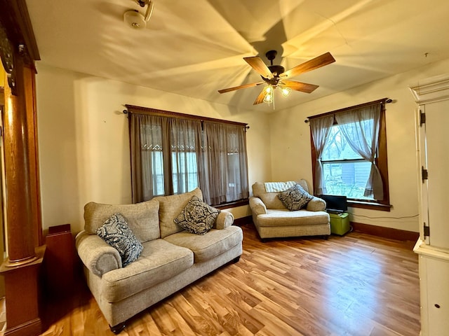 living room featuring ceiling fan, baseboards, and light wood-style floors