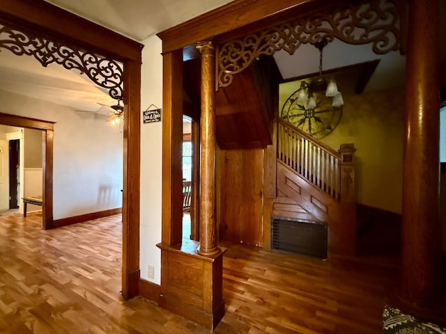 stairs featuring baseboards, a ceiling fan, decorative columns, and wood finished floors