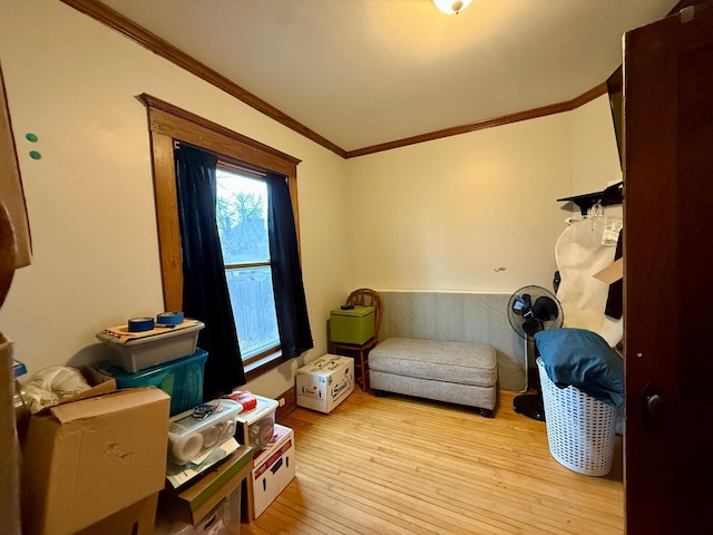 sitting room with ornamental molding and light wood-style flooring