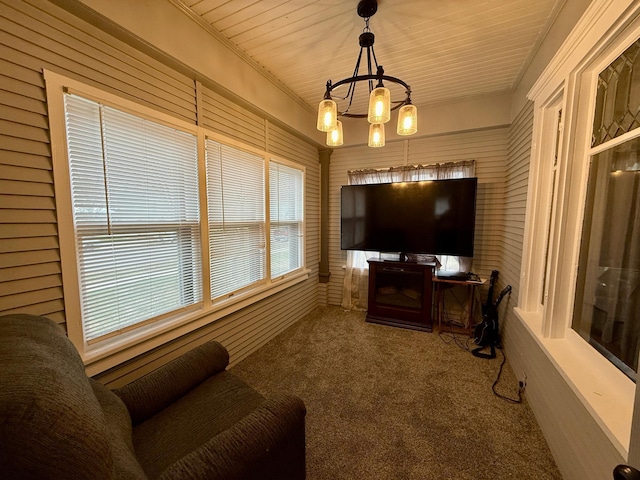 living area with an inviting chandelier, wooden ceiling, and carpet