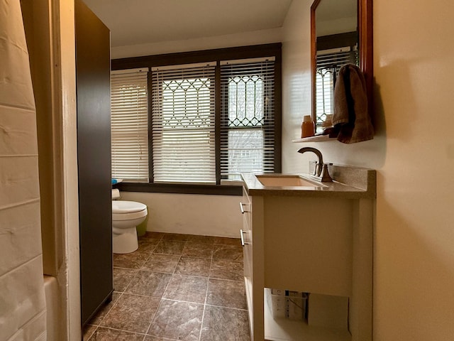 bathroom with vanity, stone finish floor, and toilet