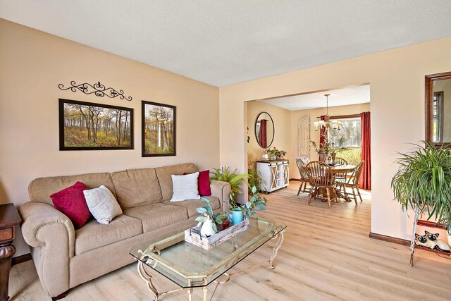 living area featuring baseboards and light wood finished floors