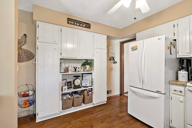 kitchen featuring white appliances, ceiling fan, dark wood-style floors, and white cabinets