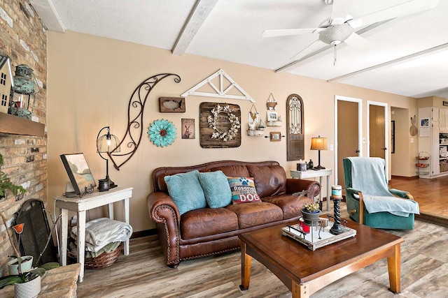 living area with baseboards, a ceiling fan, wood finished floors, and beamed ceiling