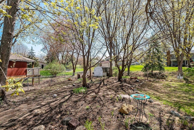 view of yard with fence, an outdoor structure, and a shed
