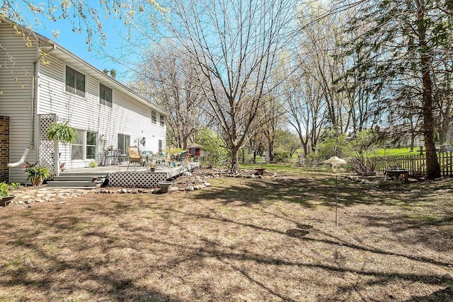 view of yard with a deck and fence