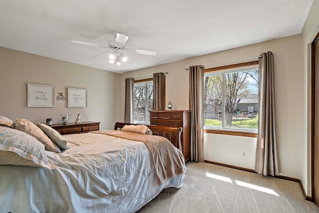 bedroom with light colored carpet, baseboards, and ceiling fan