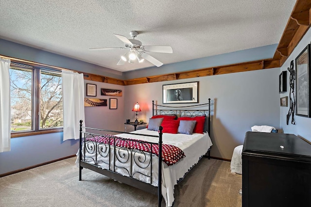 bedroom with carpet floors, a textured ceiling, baseboards, and a ceiling fan