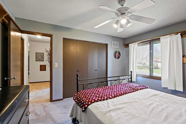 bedroom featuring ceiling fan, light colored carpet, a textured ceiling, visible vents, and a closet