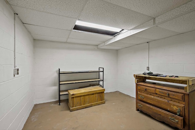 finished below grade area featuring concrete block wall and a drop ceiling