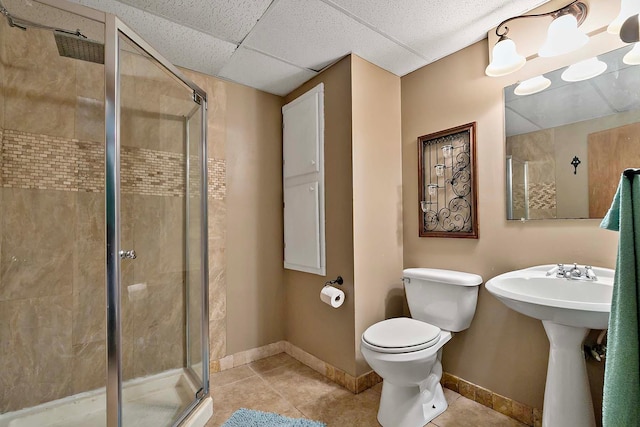 full bathroom featuring tile patterned flooring, baseboards, toilet, and a shower stall