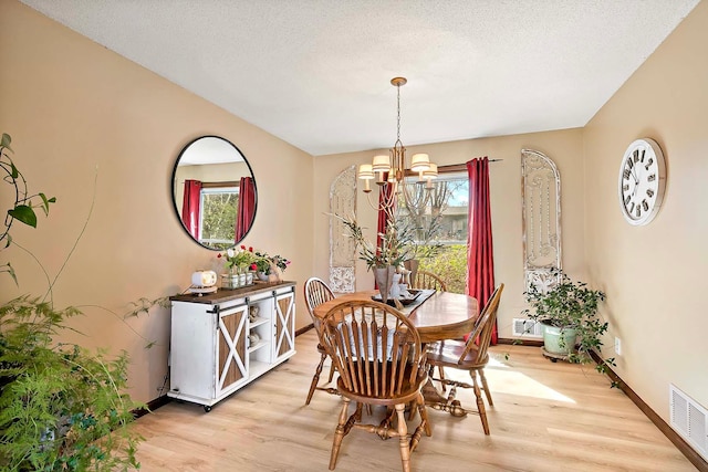 1713 James Pl, Burnsville, MN 55337 - dining space with a chandelier, light wood-type flooring, baseboards, and a textured ceiling