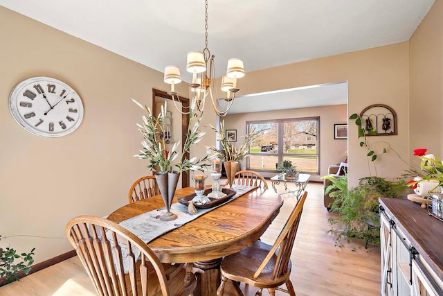 1713 James Pl, Burnsville, MN 55337 - dining area with light wood-type flooring, a chandelier, and baseboards