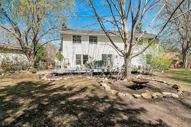 1713 James Pl, Burnsville, MN 55337 - rear view of house featuring a wooden deck, a chimney, and a lawn