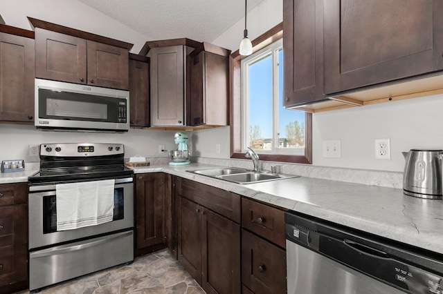 kitchen featuring a sink, stainless steel appliances, dark brown cabinetry, a textured ceiling, and light countertops