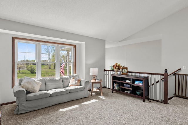 carpeted living area featuring vaulted ceiling and baseboards