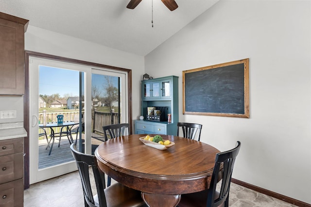 dining room with a ceiling fan, baseboards, and lofted ceiling