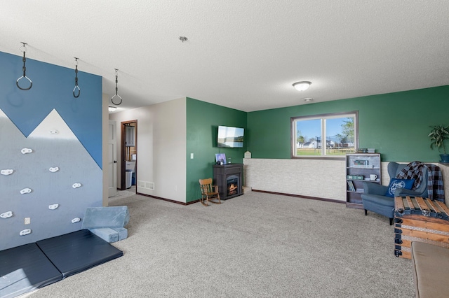 rec room with carpet flooring, a textured ceiling, and visible vents
