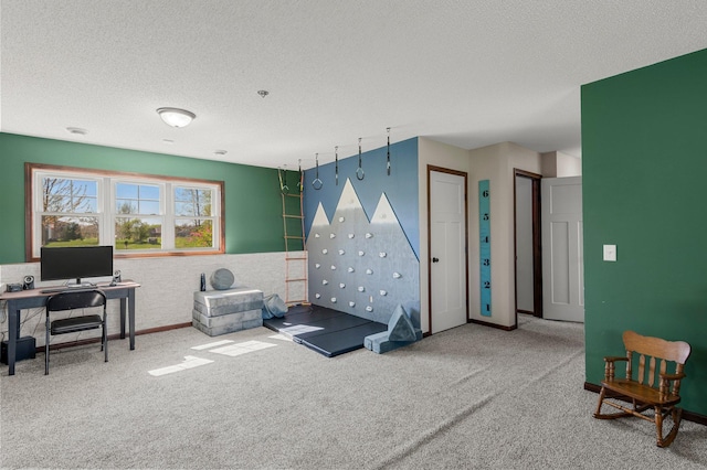 recreation room featuring carpet and a textured ceiling