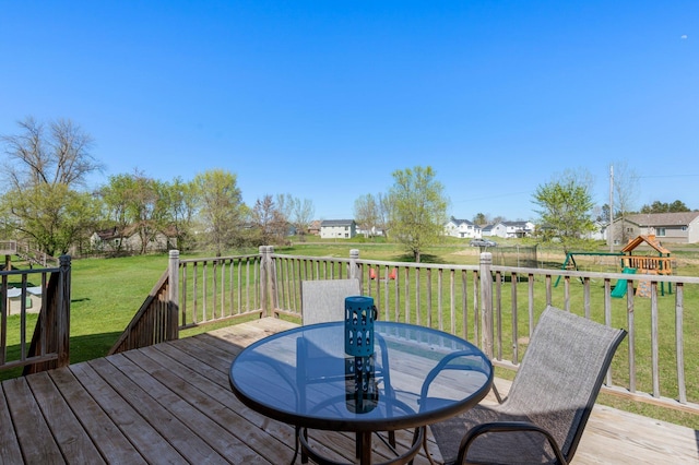 deck with a yard, a playground, outdoor dining space, and a residential view