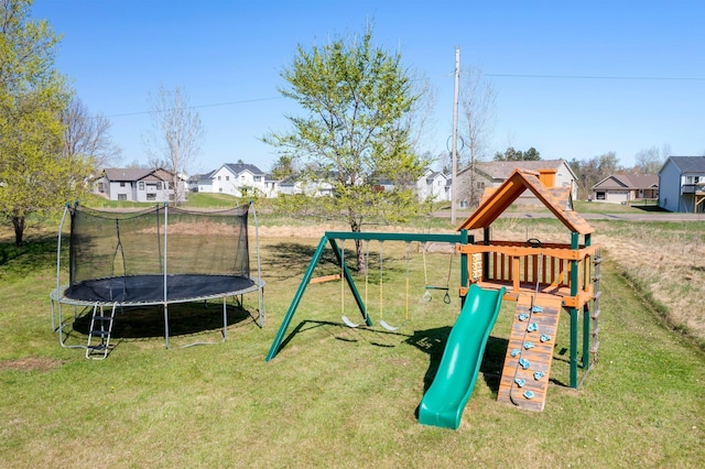 view of playground featuring a yard, a trampoline, and a residential view