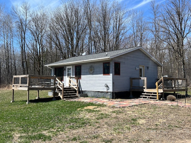 manufactured / mobile home featuring a wooden deck and a front lawn
