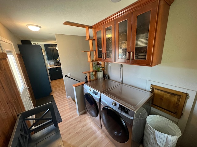 washroom featuring separate washer and dryer, laundry area, and light wood finished floors