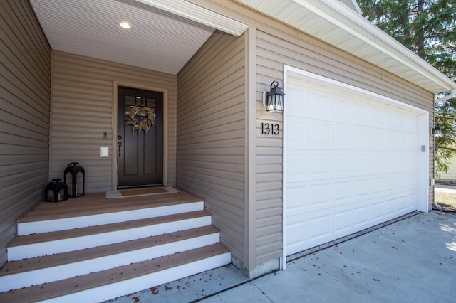 doorway to property featuring a garage and concrete driveway