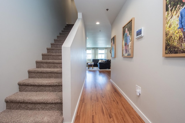 staircase with baseboards, recessed lighting, and wood finished floors